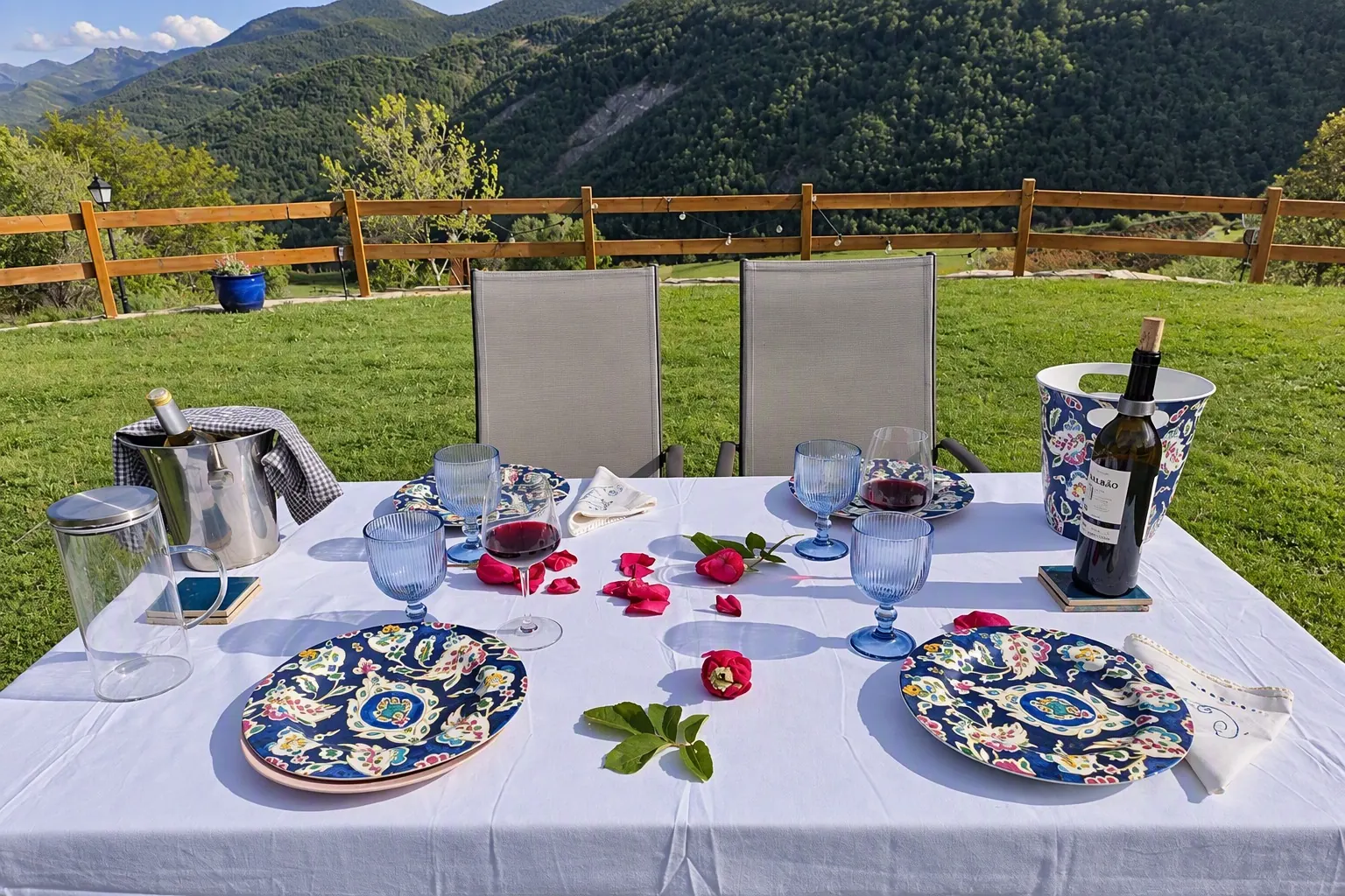Mesa puesta en la era con vajilla de cerámica y vistas a la montaña