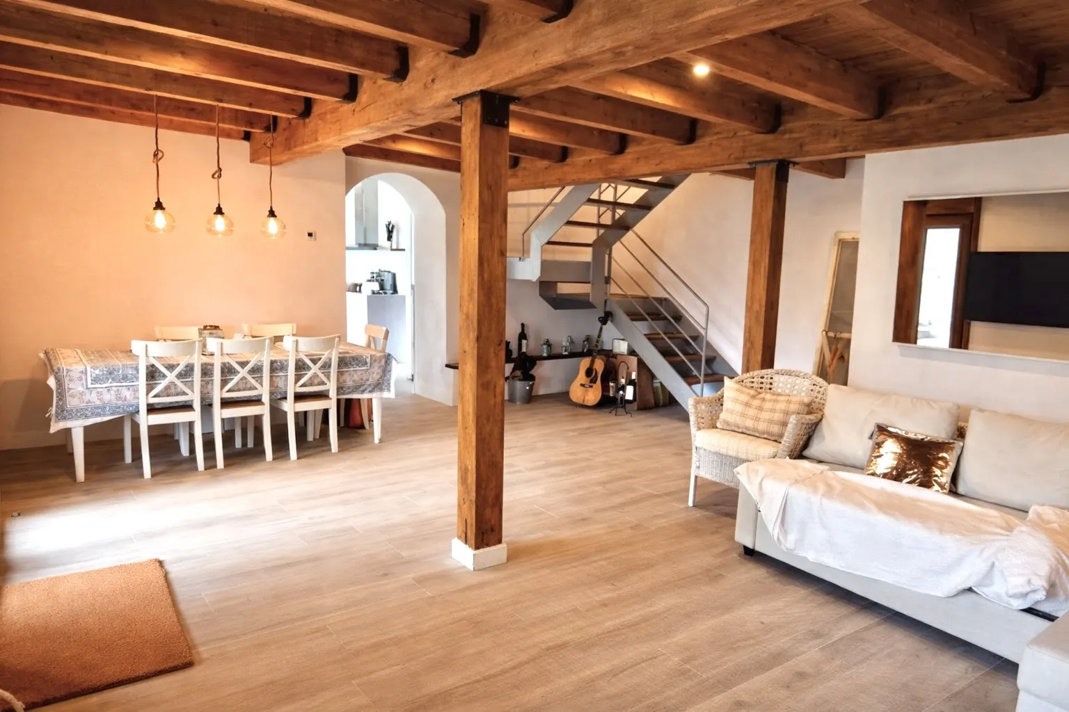 Salón comedor con vigas de madera y escalera